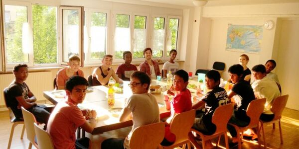 Unbegleitete Minderjährige am Esstisch in der Gruppe